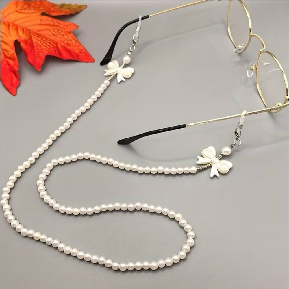 Eyeglass necklace holders, one black and  white and one white